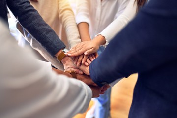 Group of business workers standing with hands together at the office