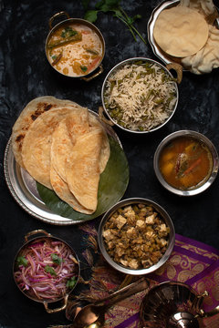 Indian vegan thali meal with rice pilaf, paratha, dal, mushroom tofu curry