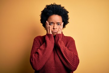 Fototapeta na wymiar Young beautiful African American afro woman with curly hair wearing casual turtleneck sweater Tired hands covering face, depression and sadness, upset and irritated for problem