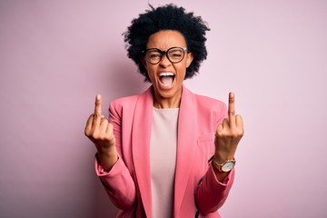 Young beautiful African American afro businesswoman with curly hair wearing pink jacket Showing...