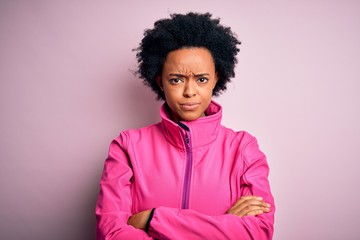 Young African American afro sportswoman with curly hair wearing sportswear doin sport skeptic and...