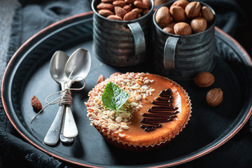 Enjoy your cheesecake with almonds on dark plate