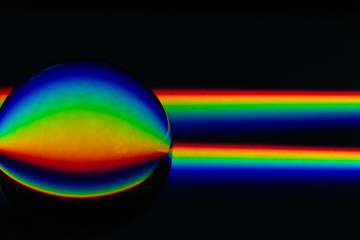 Two beams of broken light displaying the colors of the raibow, visible spectrum of light, being...