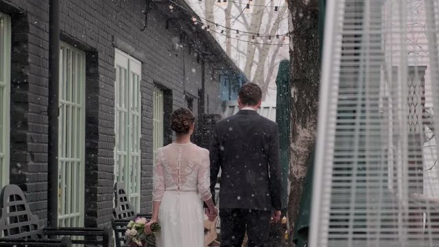 man and woman walk down the street in winter
