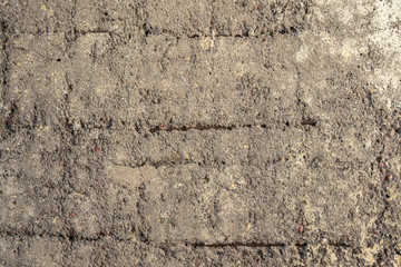 old heavily damaged gray concrete wall with protruding rusty reinforcement. rough surface texture