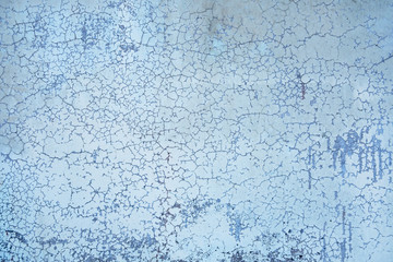 old blue wall with small cracks and spots of dark paint. rough surface texture