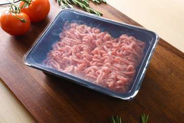 minced meat in packing on a wooden background