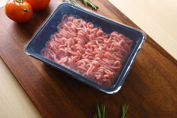 minced meat in packing on a wooden background
