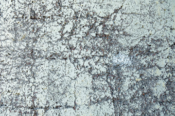 old ragged white wall with gray cracks and protruding stones. rough surface texture