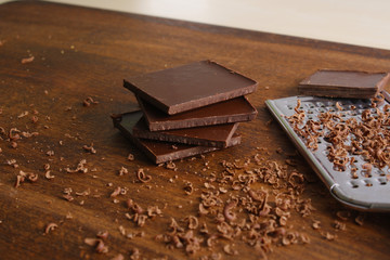 grated chocolate on a wooden background grater