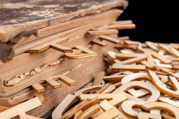 Old book and wooden letters. Wooden letters spilling out of the book.