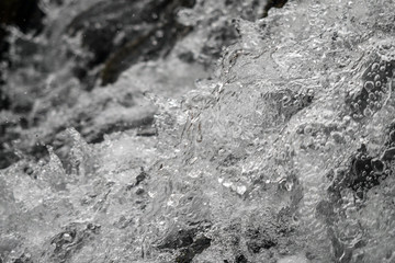 Water splashes in a small creek, abstract nature background.
