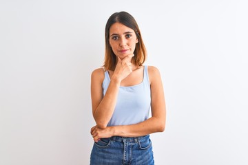 Beautiful redhead woman standing over isolated background looking confident at the camera with smile with crossed arms and hand raised on chin. Thinking positive.