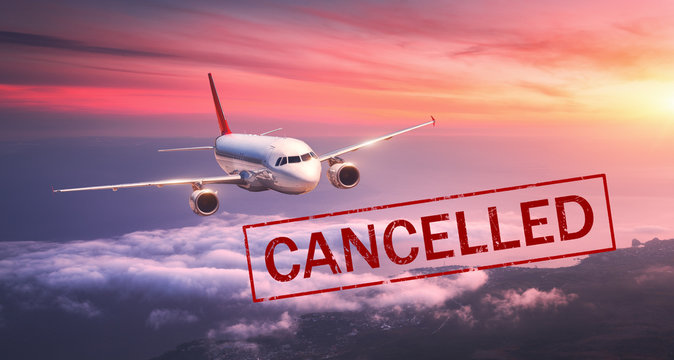 Airplane and flight cancellation. Canceled flights in Europe, Asia and USA airports. Travel cancelled because of pandemic of coronavirus. Background of flying passenger aircraft with text. Covid-19