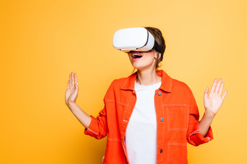 surprised girl gesturing while using vr headset on yellow background