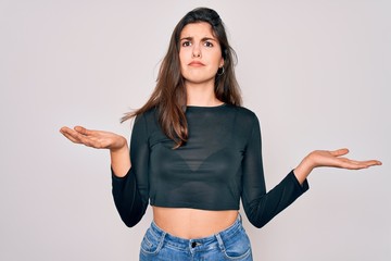 Young beautiful brunette woman wearing casual sweater and jeans standing over isolated background...