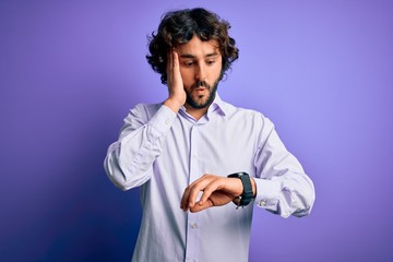 Young handsome business man with beard wearing shirt standing over purple background Looking at the...