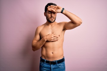 Young handsome strong man with beard shirtless standing over isolated pink background Touching forehead for illness and fever, flu and cold, virus sick