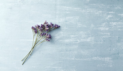 Delicate violet flowers on rustic wooden background. Copy space