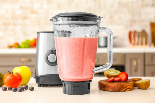 Blender with healthy smoothie on kitchen table