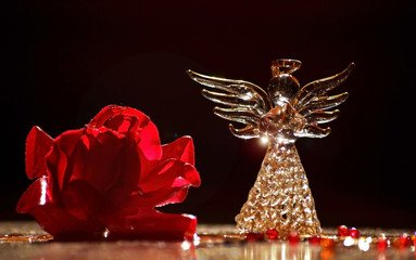 Primer plano de un adorno de vidrio en forma de ángel, en un ambiente cálido  