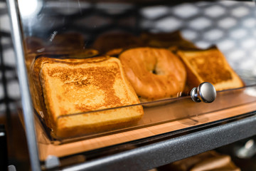 French toast and bagel bread closeup on bakery tray buffet for morning continental breakfast in hotel motel or office