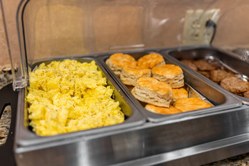 Fresh hot buffet tray selection with food scrambled eggs, biscuits and sausages in banquet, wedding, or restaurant inside for morning continental breakfast in hotel motel