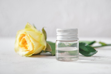 Bottle of rose essential oil on white background