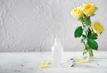 Bottle of rose essential oil on white background