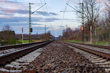 Fototapeta na wymiar Low angle and selected focus view of empty railway track near platform train station in countryside area in Germany.