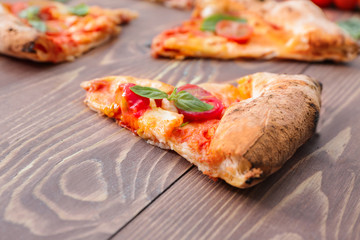 Slices of delicious pizza Margherita on wooden background