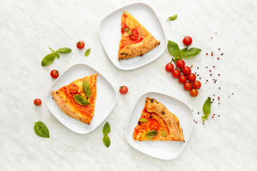Plates with slices of delicious pizza Margherita on table