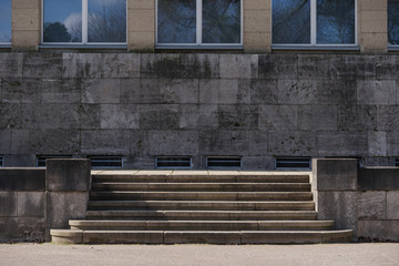 Fototapeta na wymiar Front parallel outdoor view of staircase in front of modern granite stone facade with rectangular windows.
