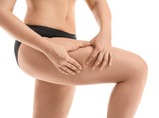 Young woman with cellulite problem on white background