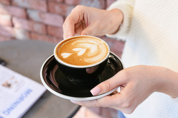 Woman drinking tasty cappuccino in cafe