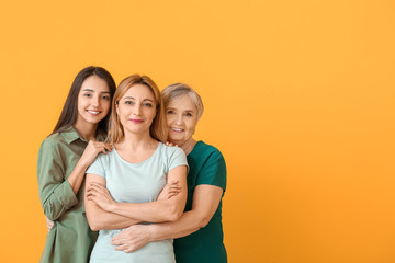 Portrait of mature woman with her adult daughter and mother on color background - obrazy, fototapety, plakaty