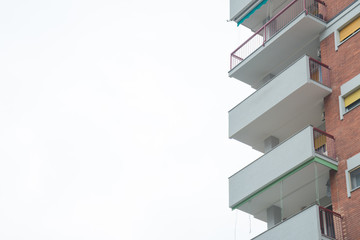 Balconies of a residential building on the right. White copy space on the left
