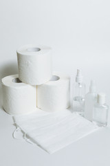 Hygiene supplies antiseptic gel, surgical mask, antibacterial spray, toilet paper on white background. COVID-19 coronavirus outbreak concept. Shortage due to buying panic. White background, copy space