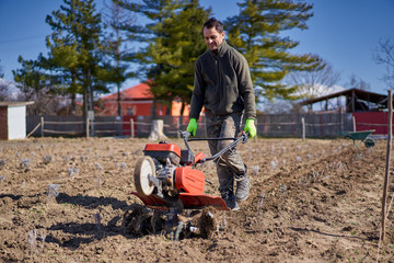 Farmer weeding the field with a tiller