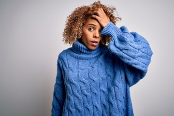 Young beautiful african american woman wearing turtleneck sweater over white background surprised...