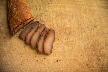 jerky meat raw smoked dish from Armenian traditional cuisine slices snacks on wooden board food background photography poster with empty copy space for your text