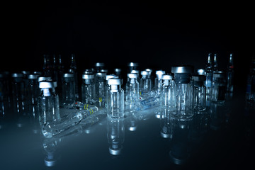 Glass medical ampoule and vials. Black background. Virus vaccination.