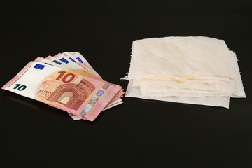 sheets of toilet paper and euro money, on black background