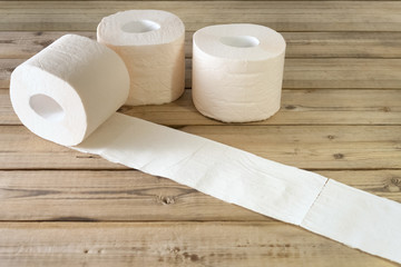  a few soft roll unwound in the way of toilet paper. on wooden background.