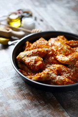 Raw chicken wings marinated in a frying pan before cooking. Cooking chicken wings. Buffalo wings recipe. Keto Paleo. Pegan.