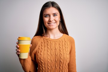 Young beautiful woman with blue eyes drinking cup of takeaway coffee over isolated background with a happy face standing and smiling with a confident smile showing teeth