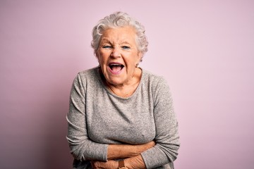 Senior beautiful woman wearing casual t-shirt standing over isolated pink background smiling and...