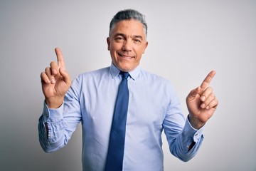 Middle age handsome grey-haired business man wearing elegant shirt and tie smiling confident pointing with fingers to different directions. Copy space for advertisement