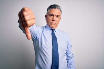 Middle age handsome grey-haired business man wearing elegant shirt and tie looking unhappy and angry showing rejection and negative with thumbs down gesture. Bad expression.