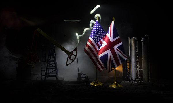 Business dialogue, oil agreement concept: National flags with Oil pump and oil refining factory at night with fog and backlight. Energy industrial concept.